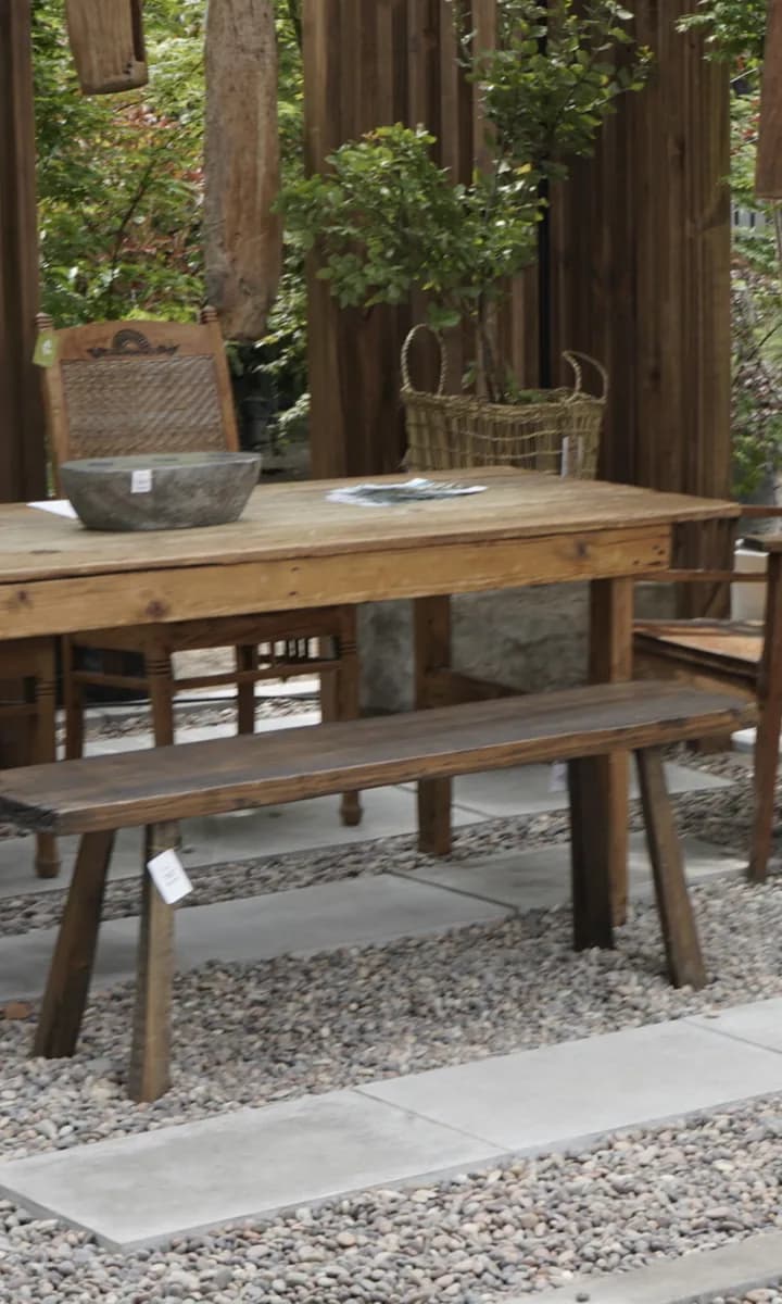 Terraza exterior con mesa, banca y pavimentos de piedra